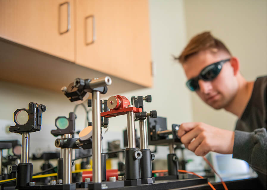 Physics student demonstrating part of a research project.