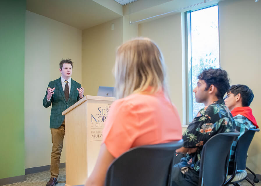 Students listening to a professor in a classroom.