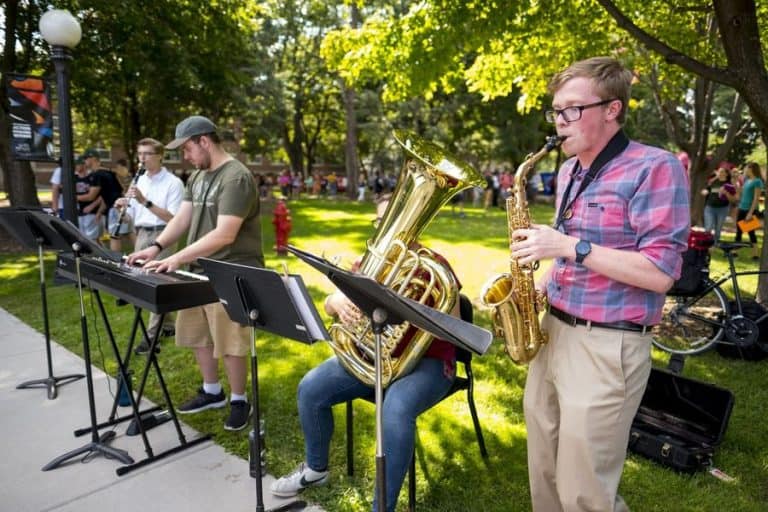 Students playing instruments outdoors on campus